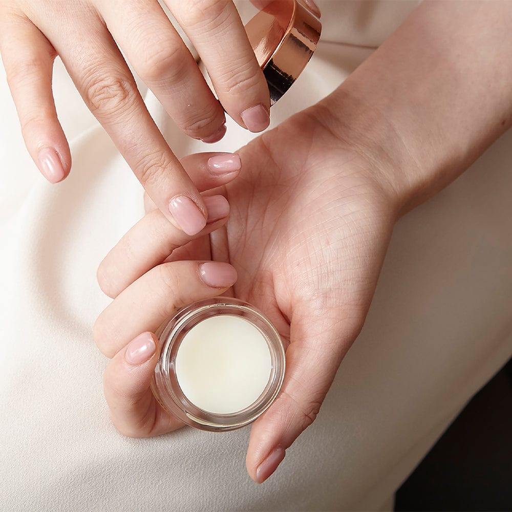 Beautiful woman applying serum to her finger tip